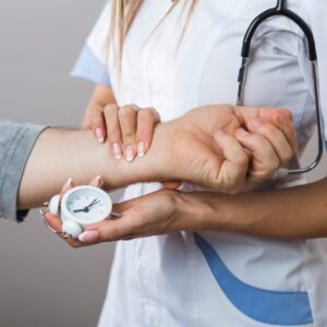 Personne en arrêt de travail vérifiant l’heure sur une horloge à son domicile.